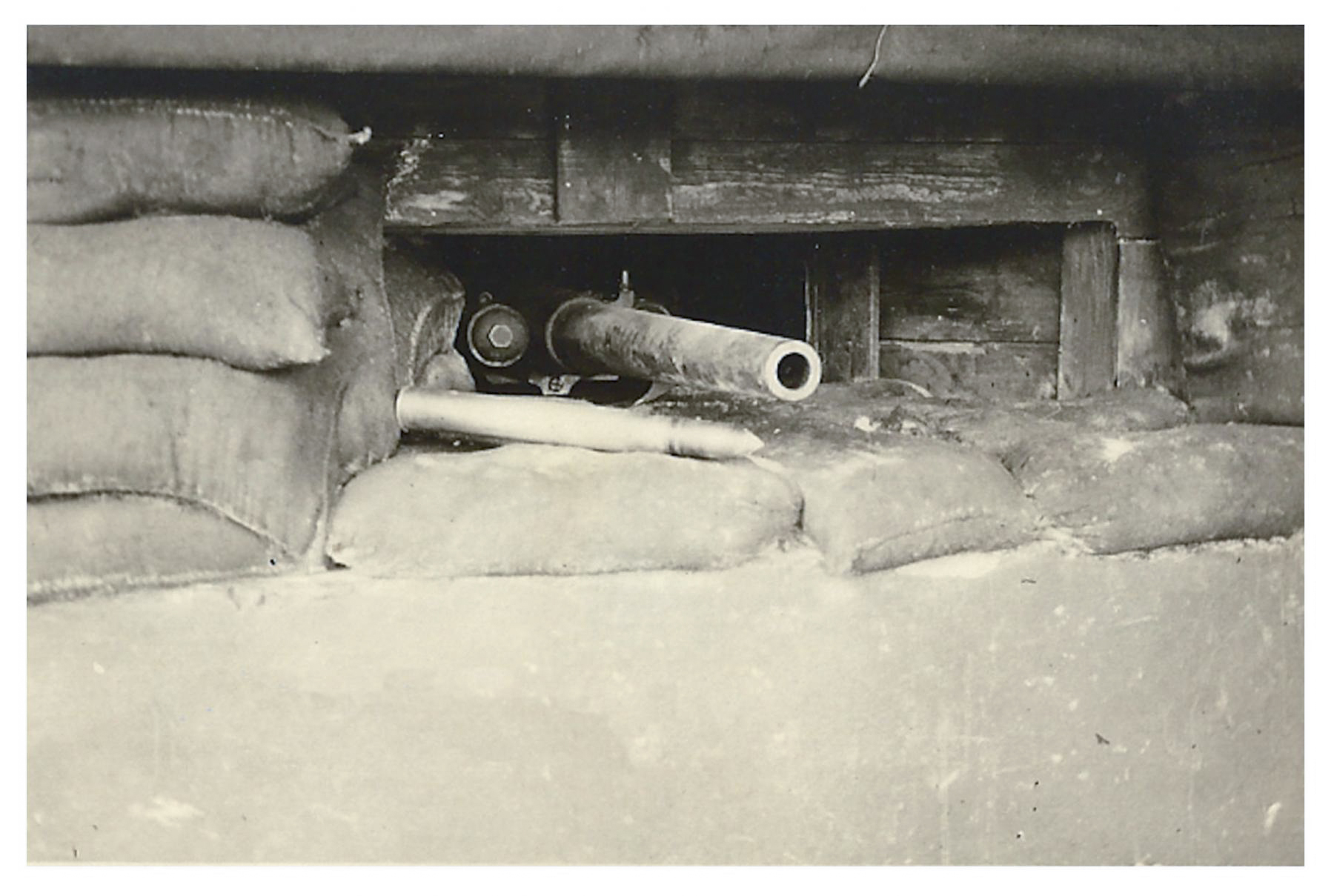 Ligne Maginot - Canon antichar de 47 mm mle 1885 - Canon en place dans un blockhaus.
Une cartouche à obus de rupture mle 1892 est visible à l'avant plan.
Noter la protection pare éclat en bois du créneau