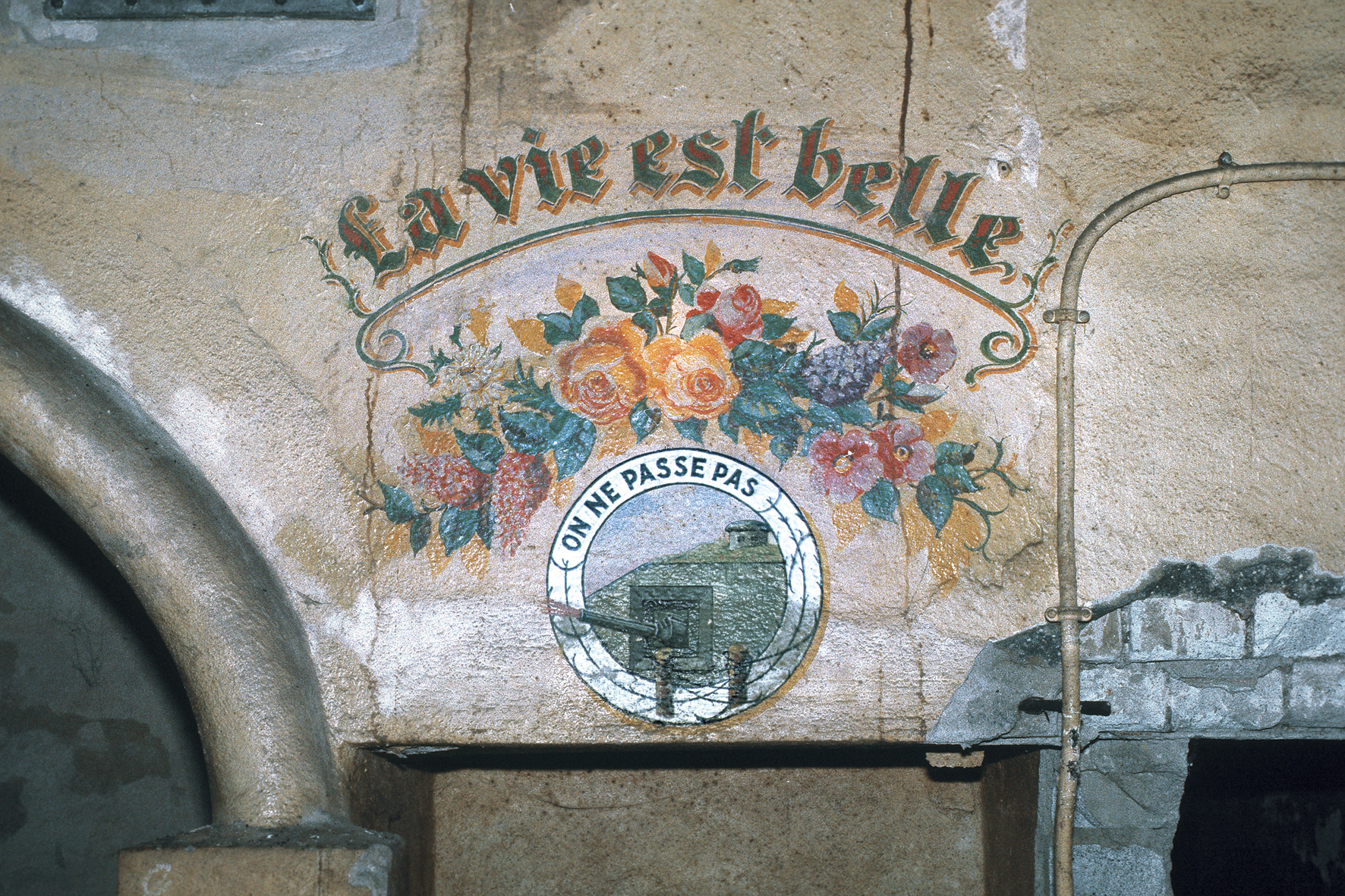 Ligne Maginot - KOBENBUSCH  - A13 - (Ouvrage d'artillerie) - La célèbre peinture murale 'La vie est belle' en chef d'un magnifique bouquet de fleurs et de l'insigne des troupes de forteresse. Photo faite en 1985 quelques jours avant l'inondation de l'ouvrage.