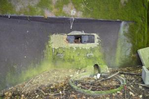 Ligne Maginot - 108 - STRENGWALD NORD - (Casemate d'infanterie - Double) - Créneau mitrailleuse, on remarque derrière les pierres le volet blindé, et au sol la fosse à douille dans laquelle débouche l'évacuation des douilles.