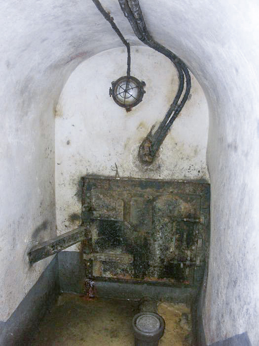 Ligne Maginot - BIRLENBACH - (Abri) - Le départ des égouts
La galerie d'égout sert d'entrée pour les cables téléphoniques. Ceux ci sont visibles au dessus de la porte.